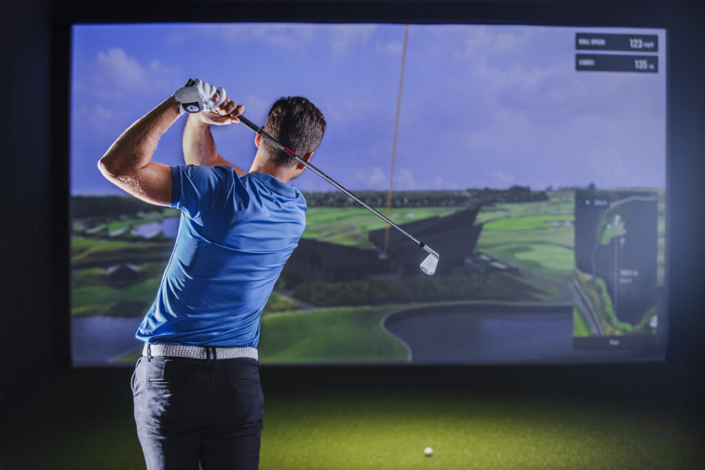 A person hitting a drive at the golf simulator at Lane7 Milton Keynes